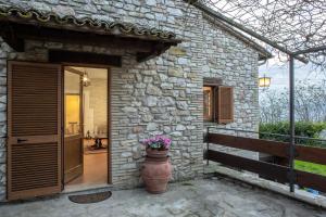 a stone house with a vase with flowers in it at Casa Vacanze L'olivo al Borghettaccio in Assisi +10 photos