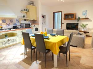 cocina y sala de estar con mesa amarilla y sillas en Casa di Corte - Cormano, en Cormano