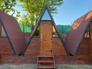 eine Holztür in einem Pyramidenhaus mit einer Leiter in der Unterkunft The Hood - Shkodra Backpackers Hostel in Shkodra