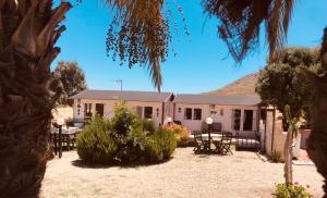 a white house with tables and chairs in front of it at PlayaArco Escullos in Los Escullos