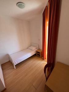 a small bedroom with a bed and a window at Apartmani Šaldi in Pakoštane