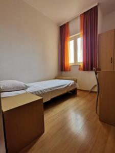 a bedroom with two beds and a window at Apartmani Šaldi in Pakoštane