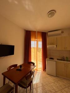 a kitchen with a wooden table and a kitchen with a table and chairs at Apartmani Šaldi in Pakoštane