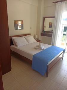 a bedroom with a large bed with a blue blanket at Eleni's in Kriopigi