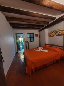 1 dormitorio con 1 cama de color naranja en una habitación en Rustic House, en Villa de Leyva