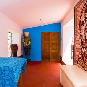 Habitación con paredes azules y puerta de madera. en Aguaymanto hostel, en Písac