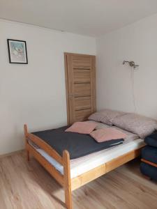 a bed with a wooden frame in a room at Apartament Muszelka in Puck