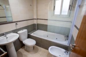 a bathroom with a toilet and a tub and a sink at Apartamento 1 Calle Tierno Galvan in Cox