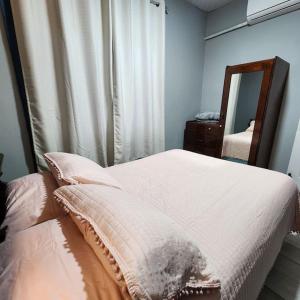 um quarto com uma cama branca e um espelho em Apartamento Alicia em Comayagua