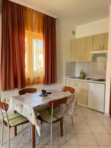 eine Küche mit einem Holztisch mit Stühlen, einem Tisch und einem Tisch in der Unterkunft Apartmani Šaldi in Pakoštane