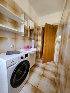 bagno con lavatrice e lavandino di Apartments Rusin a Krk