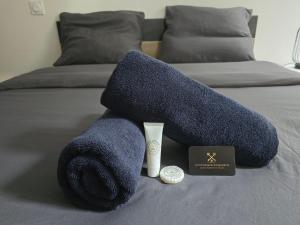 a blue towel pile on a bed with a book at Le Besson BEY II - Appartement T2 avec extérieur in Angoulême