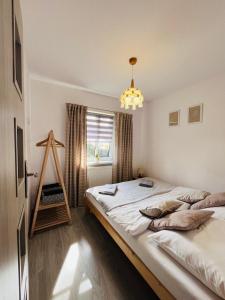 a bedroom with a large bed in front of a window at Bieszczadzkie Wyra in Ustrzyki Dolne