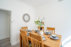 uma sala de jantar com uma mesa de madeira e cadeiras em I know you'll love this house 5min walk from beach em Great Yarmouth