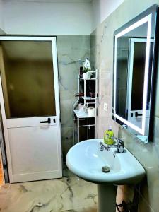 La salle de bains est pourvue d'un lavabo et d'un miroir. dans l'établissement Garden Villa Guni, à Krujë
