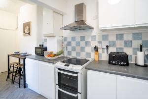 a kitchen with white cabinets and a stove top oven at I know you'll love this house 5min walk from beach in Great Yarmouth