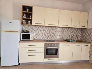 una cucina con armadietti bianchi e frigorifero bianco di Apartments Rusin a Krk