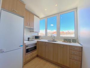 a kitchen with a sink and two windows at Apartamento en la Catedral in Burgos