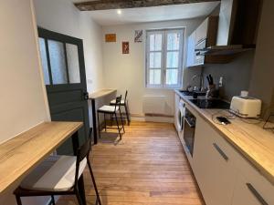 a kitchen with a counter and some chairs in it at Appartement village in Simorre