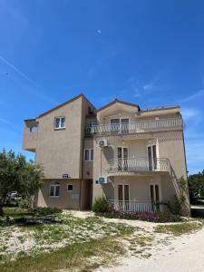 a large building with balconies on the side of it at Apartmani Šaldi in Pakoštane