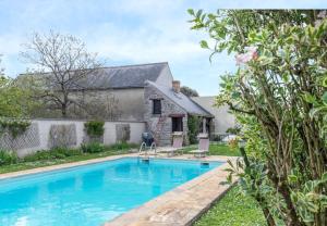 an old stone house with a swimming pool in front of it at Le Cottage de Chitenay in Chitenay