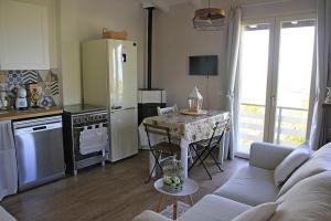 een woonkamer met een keuken met een tafel en een bank bij NiFe Tiny House - Secret Garden in Montalbo