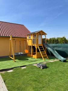a play house with a slide and a playground at Betli Panzi&oacute; in Zalaegerszeg