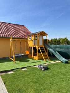 uma casa de brincar com um escorrega e um parque infantil em Betli Panzió em Zalaegerszeg