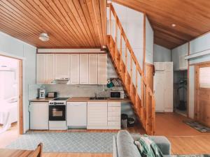 庫薩莫的住宿－Talvijärven Helmi，厨房配有白色橱柜和木制天花板