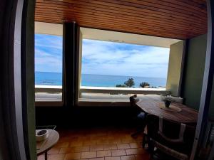 una camera con finestra affacciata sull'oceano di Solenzara charmant appartement vue mer panoramique a Sari Solenzara
