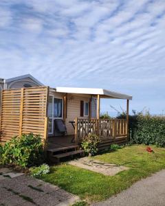 a small house with a porch and a deck at Mobil home 2 chambres vue direct sur mer in Le Portel
