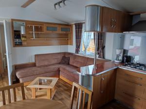 una cucina e un soggiorno con divano e tavolo di CHEZ ISA - Mobil home 2 ch - vue direct sur mer a Le Portel