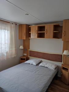 a bedroom with a bed with two white pillows at Mobil home 2 chambres vue direct sur mer in Le Portel