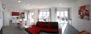ein Wohnzimmer mit einem roten Sofa und einer Küche in der Unterkunft Villa Draga Crikvenica in Crikvenica
