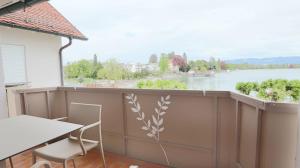 a balcony with a table and chairs and a view of a river at DaSalvatore in Wasserburg