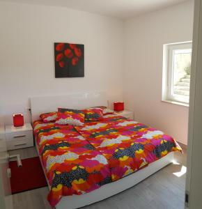 ein Bett mit farbenfroher Bettdecke in einem Schlafzimmer in der Unterkunft Villa Draga Crikvenica in Crikvenica + 20 Fotos