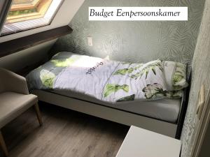 a small bed in a tiny room with a window at de Zeilende kraay in Katwijk