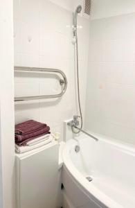 a bathroom with a white tub and a sink and a toilet at Seaview Flat in Liepāja +9 photos