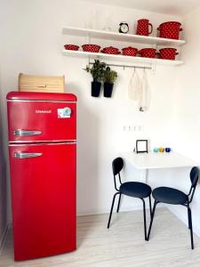 a red refrigerator in a kitchen with a table and chairs at Seaview Flat in Liepāja