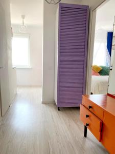 a bedroom with a purple closet and a bed at Seaview Flat in Liepāja