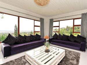 a living room with purple couches and a table at Cloud59 in Tygerberg Hills