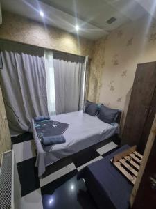 a small bedroom with a bed and a window at Formula1 in Tbilisi City