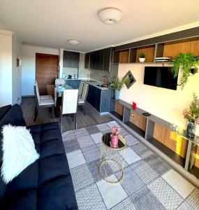 uma sala de estar com um sofá azul e uma cozinha em Moderno y acogedor dpto 2D em Los Ángeles