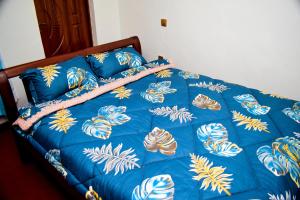 1 cama con edredón y almohadas azules en ndush home, en Rutara