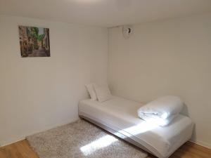 a white couch in a corner of a room at Spacious and cozy semi-basement in Lund
