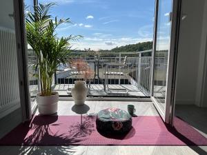 a balcony with two vases and a table on a rug at Buddha Apartment in Koblenz