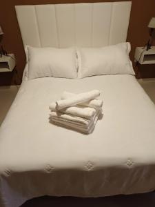 a white bed with towels on top of it at Bahia Blanca Estudio con Estacionamiento in Bahía Blanca