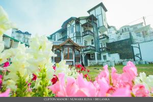 a large house with pink flowers in front of it at CLIFTON Manor luxury boutique hotel in Nuwara Eliya