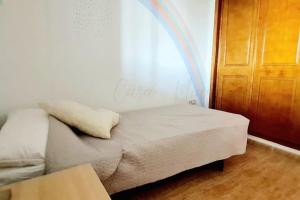 a bed in a room with a rainbow on the wall at Agréable appartement avec piscine commune in San Pedro del Pinatar +10 photos