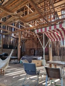 stodoła z krzesłami, stołami i parasolem w obiekcie Gites d’alsace w mieście Epfig